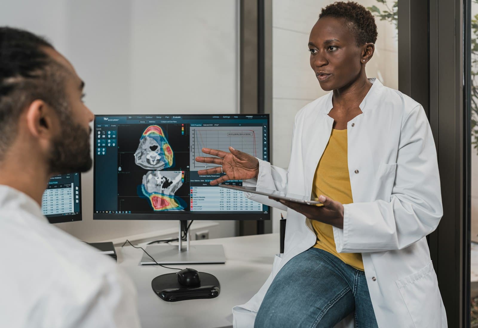 Two clinicians reviewing a patient chart together at a workstation