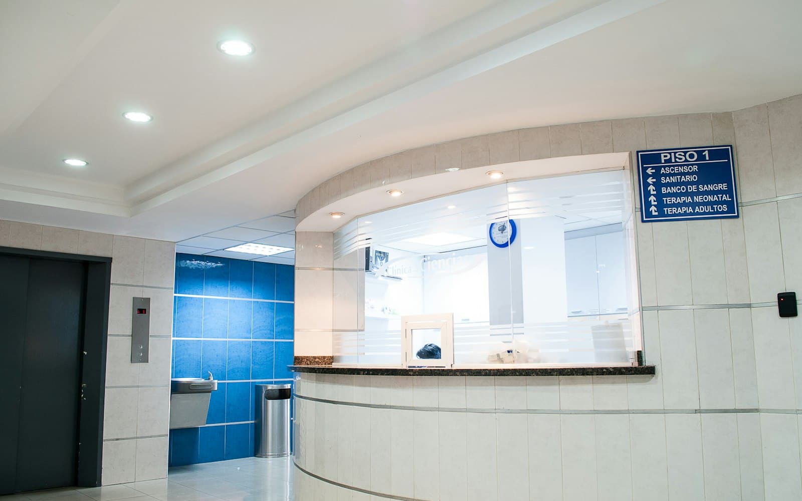 A clinic reception desk with a computer and signage