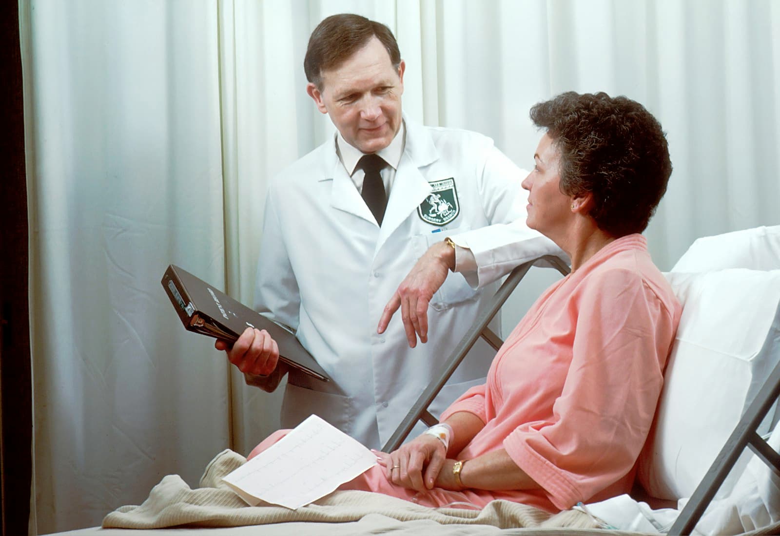 A physician talking with a patient in an exam room